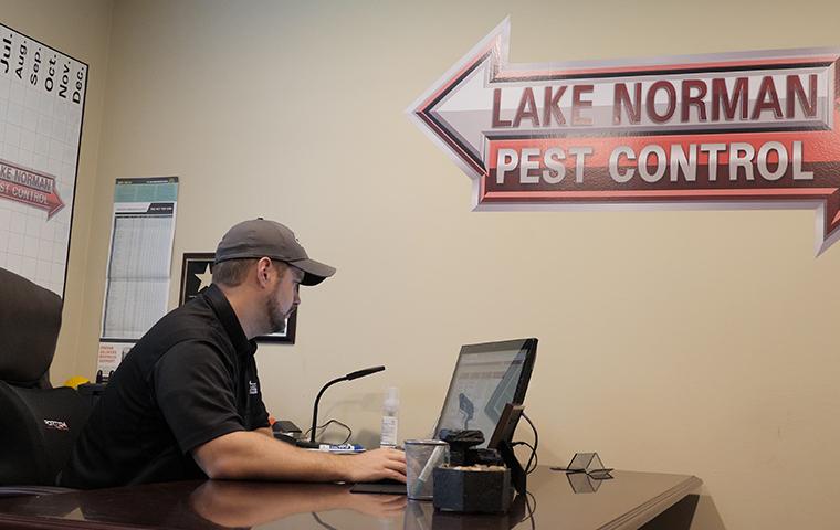 administrator working at a computer in the Lake Norman Pest Control office